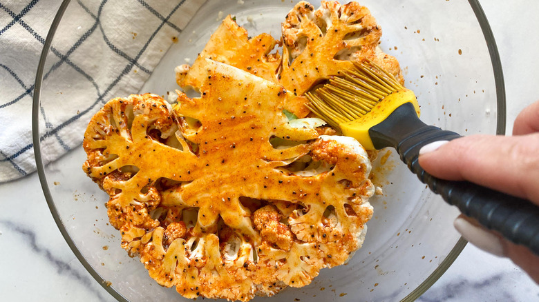 Brushing marinade on the cauliflower