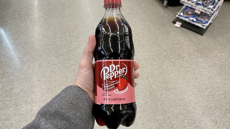 hand holding bottle of Dr Pepper